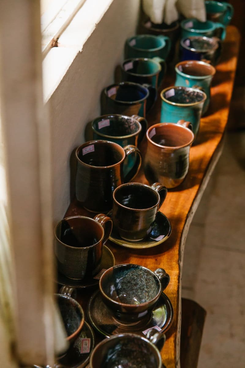 Canecas de cerâmica esmaltada em prateleira de madeira